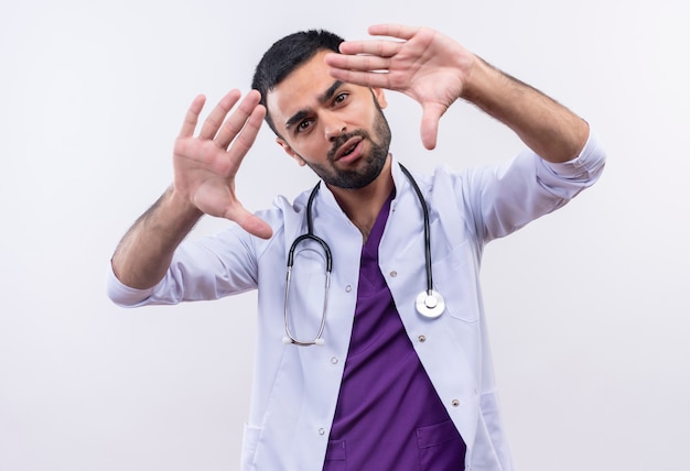 Jeune homme médecin portant une robe médicale stéthoscope - sur blanc isolé