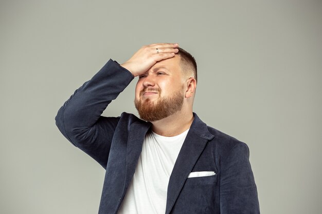 Jeune homme avec microphone sur espace gris, menant avec microphone