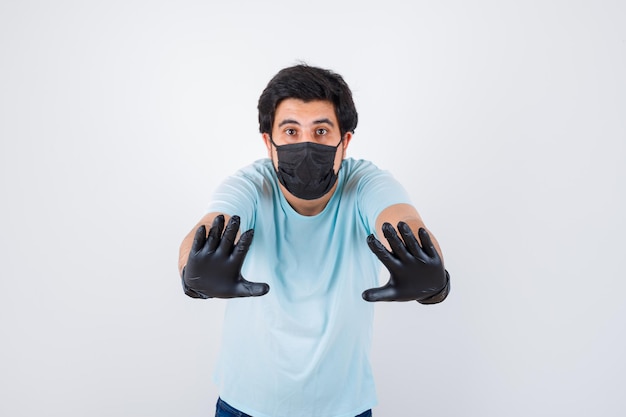 Jeune Homme Montrant Un Geste D'arrêt En T-shirt Et Ayant L'air Anxieux. Vue De Face.