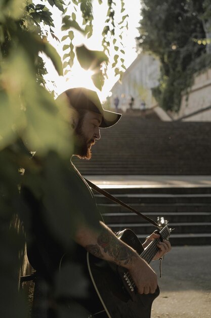 jeune homme musicien de rue joue de la guitare et chante. Notion de musique de rue.