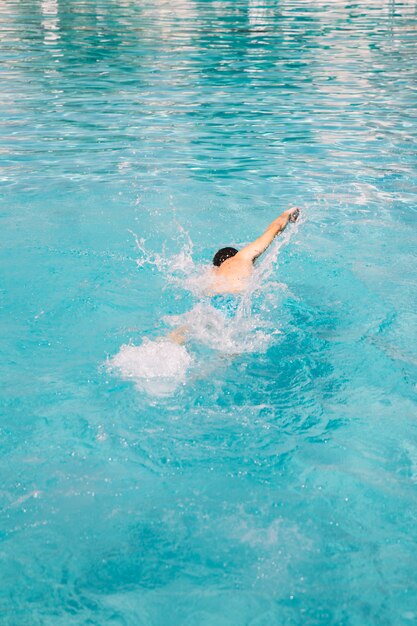 Un jeune homme nageant dans la piscine.