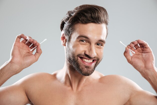 Jeune homme, à, oreille, bâtons, sourire, appareil-photo