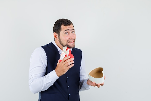 Photo gratuite jeune homme ouvrant la boîte présente en chemise, gilet et à mignon