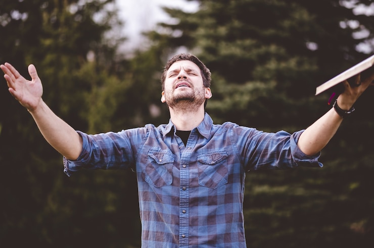Photo gratuit jeune homme parlant et tenant la bible dans ses mains