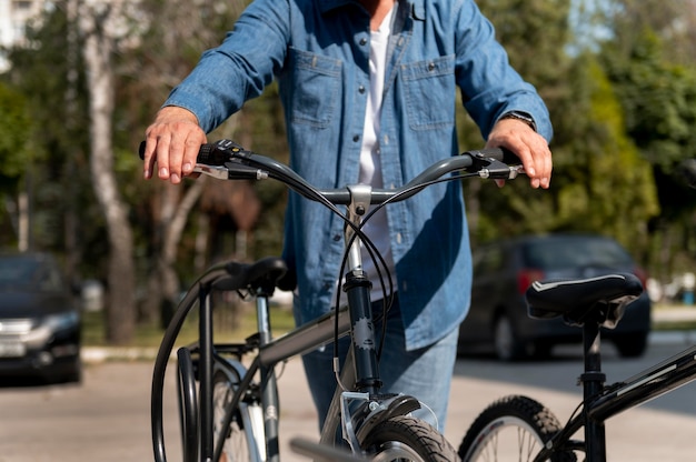 Photo gratuite jeune homme passant du temps à l'extérieur avec son vélo