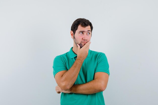 Jeune homme pensant à quelque chose sur fond blanc