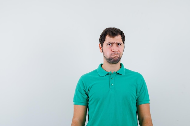 Le jeune homme pense en levant les yeux sur fond blanc