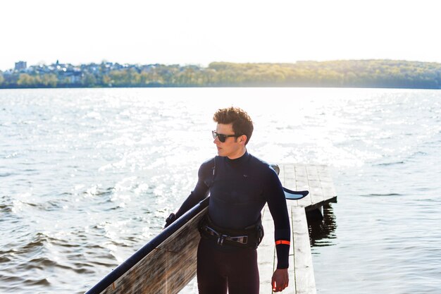 Jeune homme avec planche de kitesurf