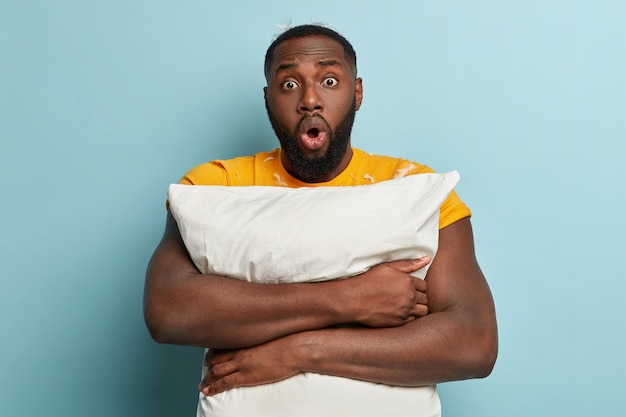 Jeune homme, à, plumes, sur, t-shirt, tenue, oreiller