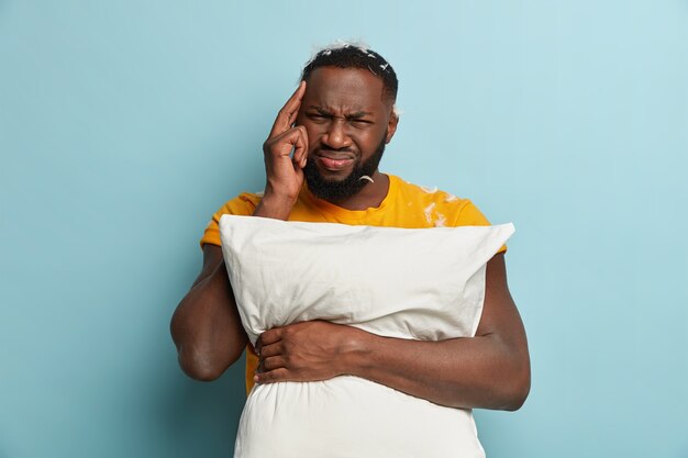 Jeune homme, à, plumes, sur, t-shirt, tenue, oreiller