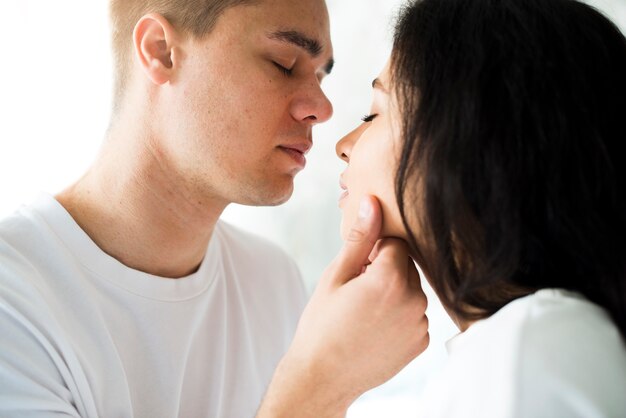 Jeune homme sur le point d&#39;embrasser une petite femme ethnique