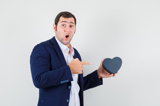 Jeune homme pointant sur une boîte-cadeau en chemise