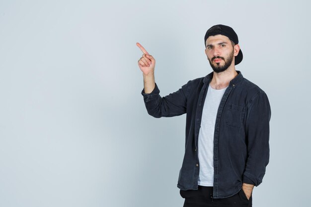 Jeune homme pointant vers le coin supérieur gauche