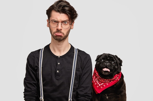 Jeune homme portant un bandana rouge et une chemise noire et son chien