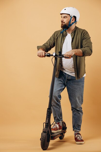 Jeune homme portant un casque de sécurité et faisant du scooter électrique