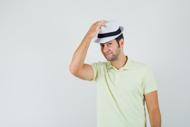 Jeune homme portant un chapeau en t-shirt et à la recherche de beau.