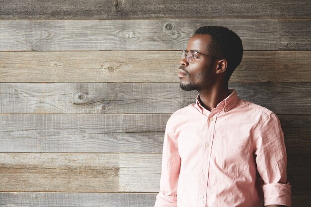 Jeune homme portant des lunettes et une chemise rose