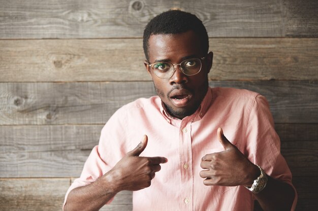 Jeune homme portant des lunettes et une chemise rose