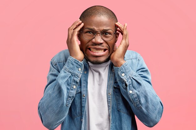 Jeune homme portant des lunettes à la mode et une chemise en jean