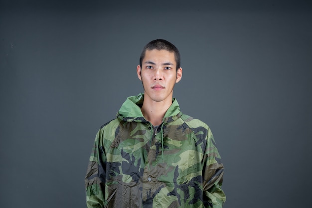 Photo gratuite le jeune homme porte un imperméable de camouflage et montre différents gestes.