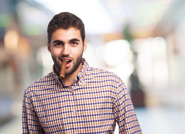 Jeune homme posant avec cigare.