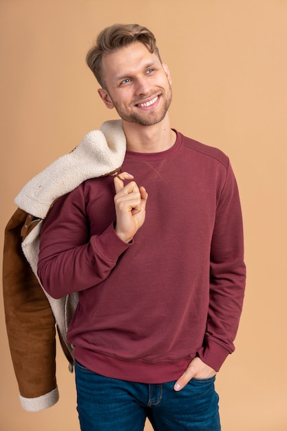 Photo gratuite jeune homme posant et souriant avant de se préparer pour le voyage