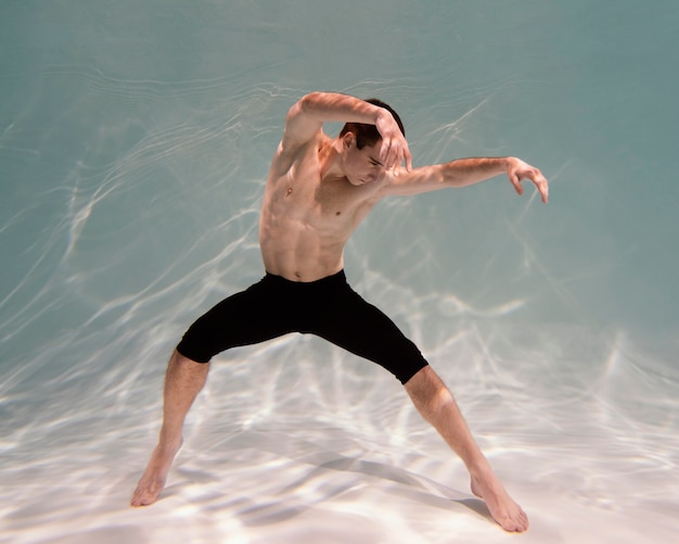 Photo gratuite jeune homme posant sous l'eau
