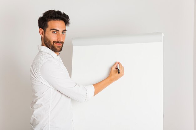 Jeune homme posant avec tableau blanc