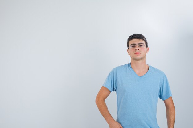 Jeune homme posant tout en regardant la caméra en t-shirt et à la vue sérieuse, de face.