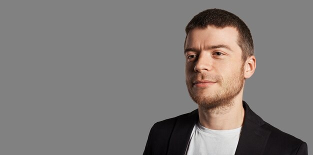 Jeune homme posant avec veste noire et t-shirt blanc