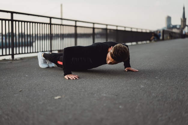 Jeune homme pratiquant des sports dans une ville européenne. Sports en milieu urbain.