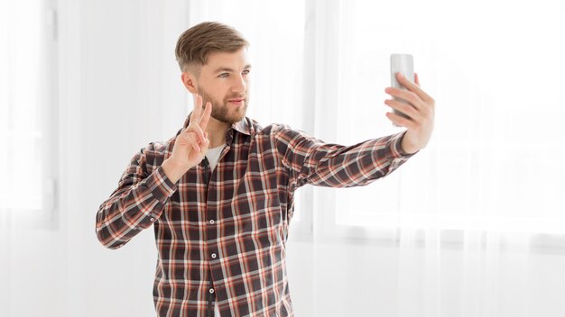Jeune homme prenant selfie