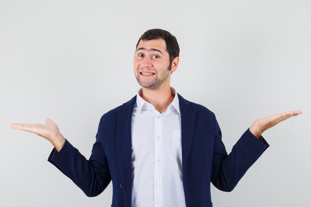 Jeune homme présentant ou comparant quelque chose en chemise