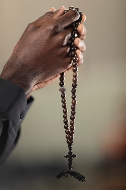Photo gratuite jeune homme prêtre priant à l'église avec chapelet