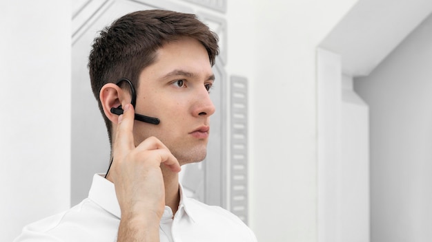 Photo gratuite jeune homme avec le prototype de la main activant le casque bluetooth