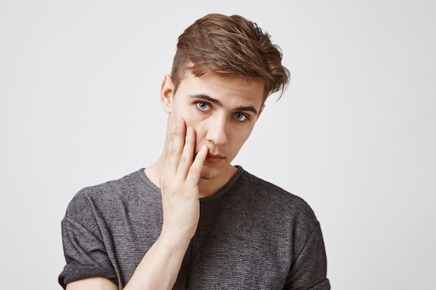 jeune homme qui a l'air fatigué et malheureux.