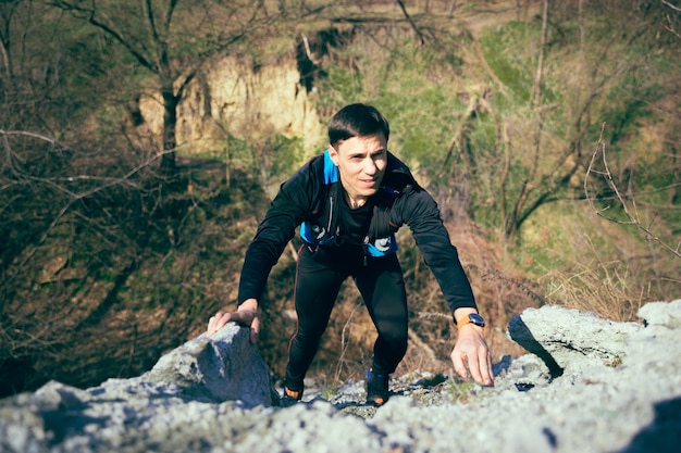 Jeune homme qui court à la forêt.