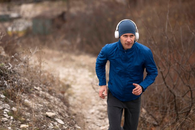 Jeune homme qui court sur le sentier dans la nature