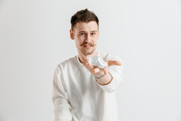 Jeune homme de race blanche avec une expression heureuse surprise a remporté un pari sur le studio gris.