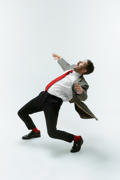 Jeune homme de race blanche se déplaçant flexible sur mur blanc