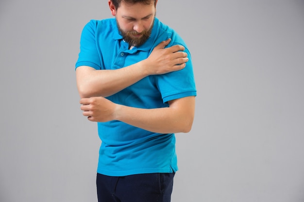 Jeune homme de race blanche souffre de douleurs à l'épaule