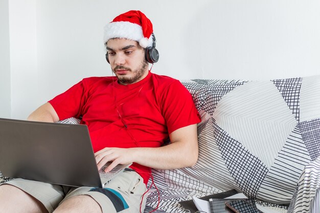 Jeune homme de race blanche travaillant à domicile pendant la saison de Noël