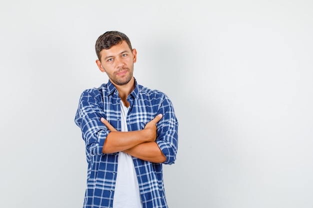 Jeune homme à la recherche de bras croisés en vue de face de chemise.