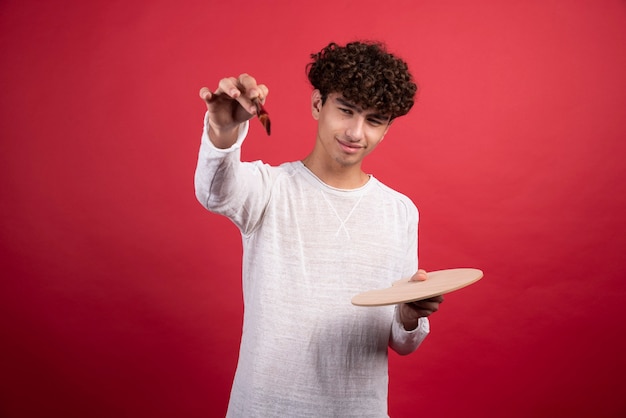 Jeune homme réfléchi à la façon de dessiner.