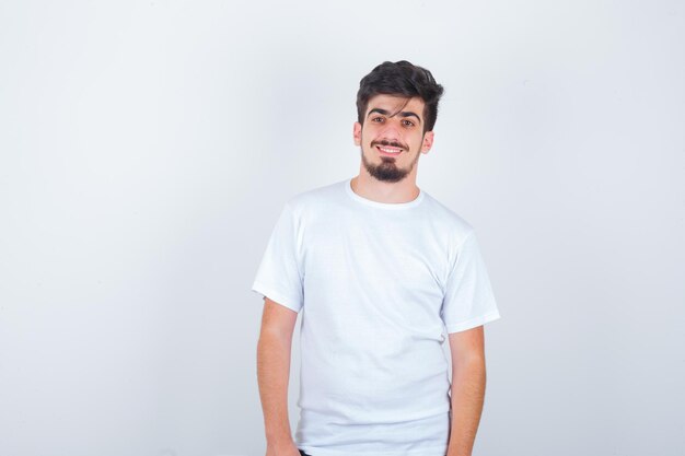 Jeune homme regardant la caméra en t-shirt blanc et élégant