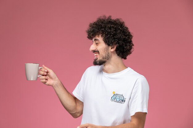 jeune homme riant avec sa tasse