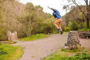 Photo gratuite jeune homme sautant dans la nature