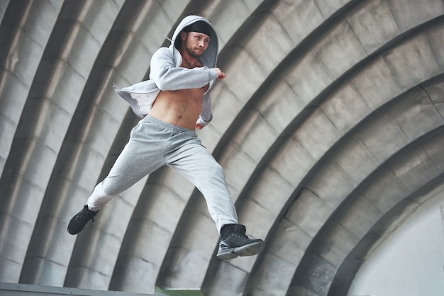 Un jeune homme saute. Parkour en espace urbain, activité sportive.