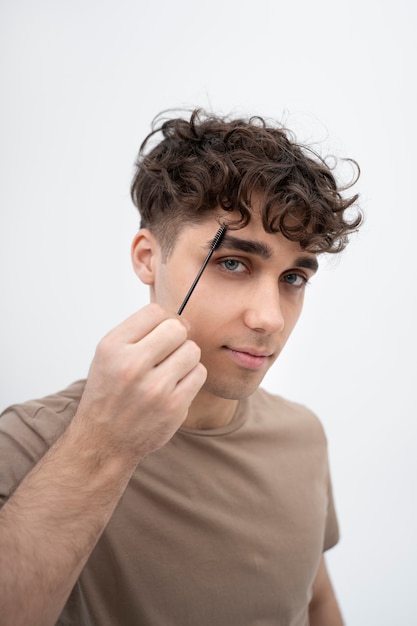 Photo gratuite jeune homme se brossant les sourcils