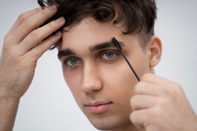 Jeune homme se brossant les sourcils